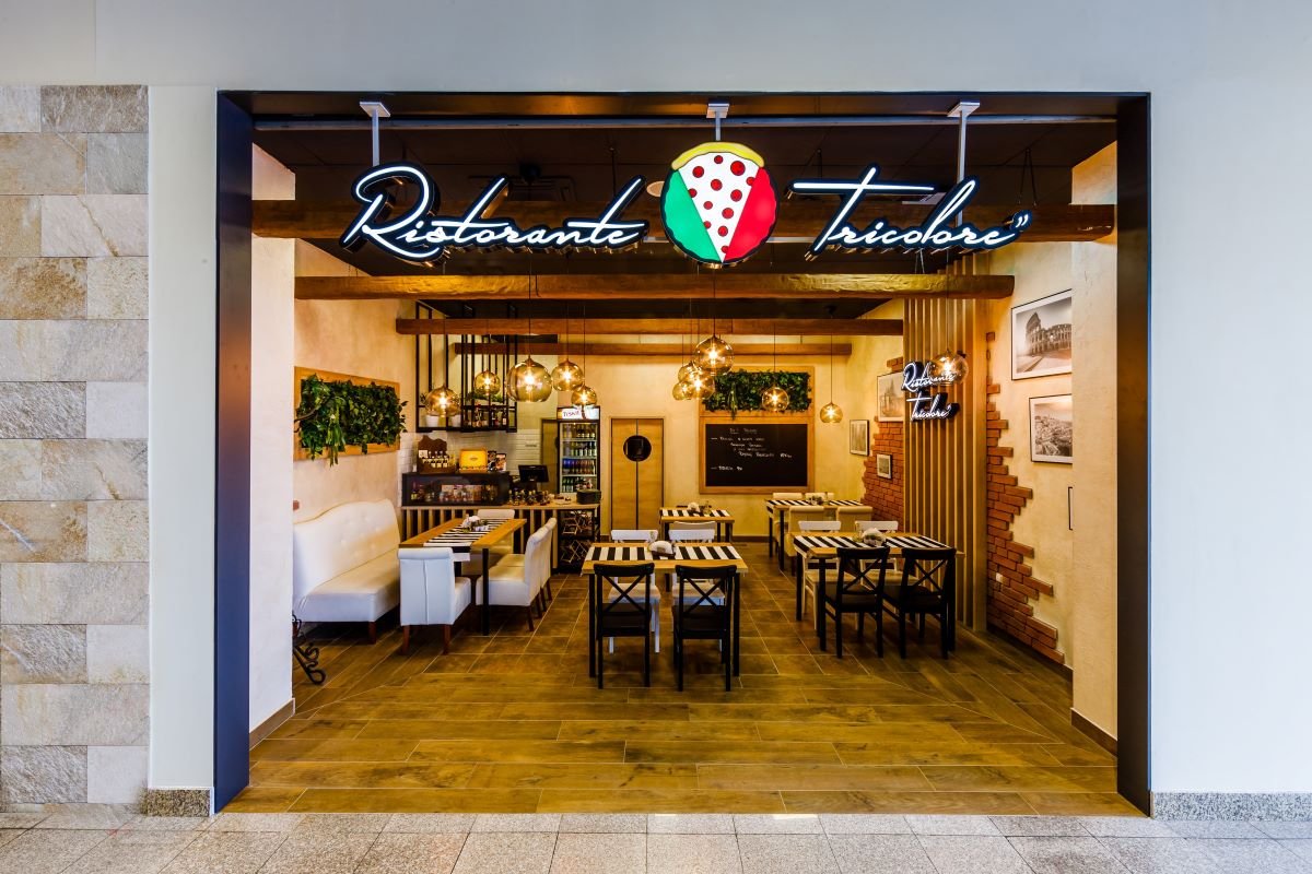 Wejście do restauracji włoskiej z neonem Ristorante Tricolore