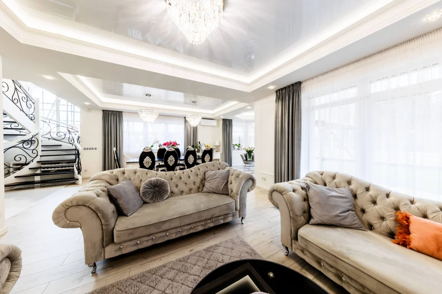 Salon z pikowanymi sofami typu chesterfield i kryształowym żyrandolem