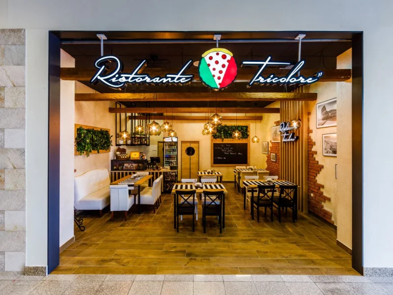 Wejście do restauracji włoskiej z neonem Ristorante Tricolore